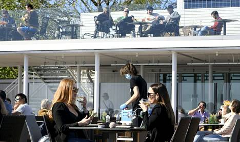 Ystävän tulotaso voi vaikuttaa esimerkiksi siihen, mitä yhdessä voidaan tehdä. Asiakkaita Cafe Caruselin terassilla Helsingin Kaivopuistossa toukokuussa 2021.