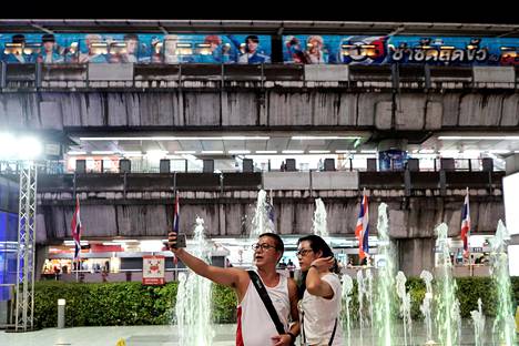 Turistit kuvasivat selfieitä kauppakeskuksen edustalla Bangkokissa syyskuussa.