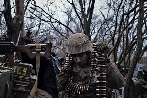 Ukrainalaissotilas valmistautui lataamaan konekivääriä etulinjassa Bahmutin lähellä.