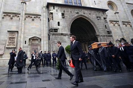 Niki Laudan pojat Lukas ja Matias kantoivat seppelettä ja isänsä ajokypärää muistotilaisuudessa.