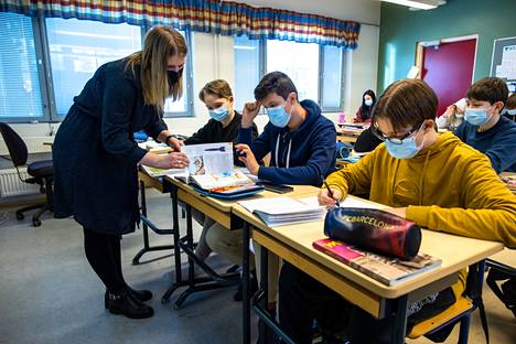 Itä-Suomen koulun opettaja Maria-Helena Forsblom opastaa historian tunnilla Robert Niemelää, Markus Hännistä ja Aleksi Tuuvaa.
