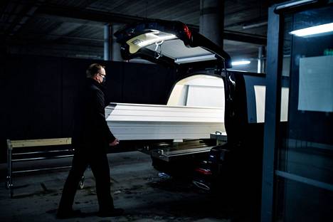 Vainajien kuljettaja Juha Muurimäki siirsi arkkua autoon Jorvin sairaalan parkkipaikalla viime helmikuussa.