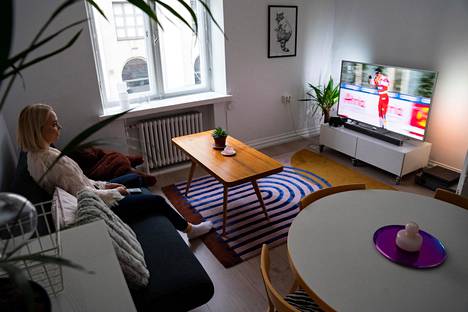 Noora Vuorimies katsoo televisiota kotonaan Helsingissä. Kuvassa näkyvät keittiöryhmä, sohvapöytä ja tv-taso ovat kaikki löytyneet uuteen kotiin internetin myyntipalveluista.
