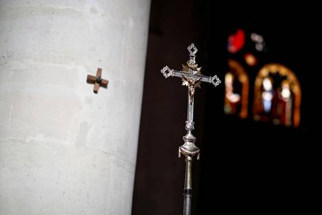 Pappi kantoi ristiä katolisessa messussa pitkäperjantaina pariisilaisessa kirkossa.