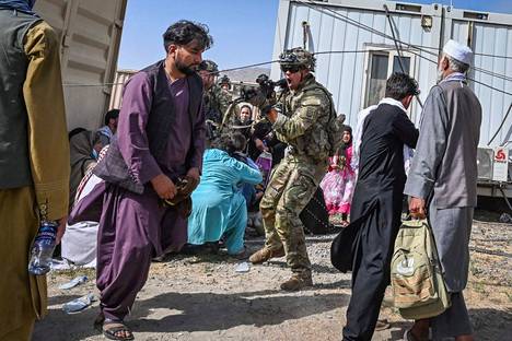 Yhdysvaltalaissotilas osoittaa aseellaan afganilaista miestä Kabulin lentokentällä Afganistanissa 16. elokuuta.