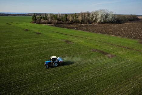 Ukrainalainen maanviljelijä levitti lannoitetta pellolleen Harkovan lähellä huhtikuussa. Ukrainassa kylvöt ovat käynnissä, ja paikalliset tahot ennustavat sadon määrän vähenevän noin 40 prosenttia edellisvuodesta.