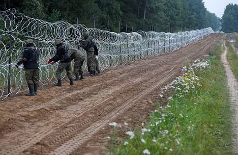 Puolan sotilaat rakensivat kulkuesteitä Puolan ja Valko-Venäjän rajalle Nomikin kylän lähellä elokuussa 2021.