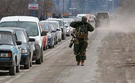 Venäjän miehitysjoukkojen sotilas käveli ohi Mariupolista pakenevien autoilijoiden.