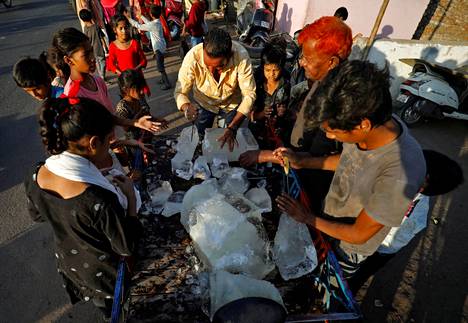 Mies jakoi jäätä slummissa Intian Ahmedabadissa 28. huhtikuuta.