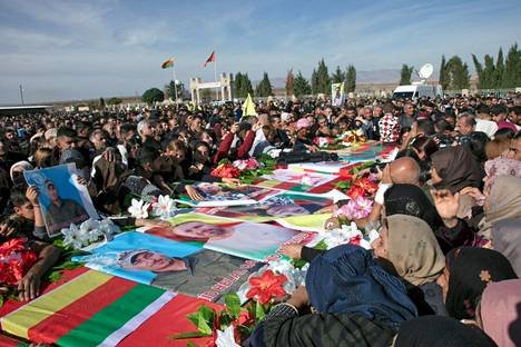 Omaiset surivat ilmaiskuissa kuolleiden ihmisten arkkujen äärellä Koillis-Syyrian Hasakassa maanantaina. 