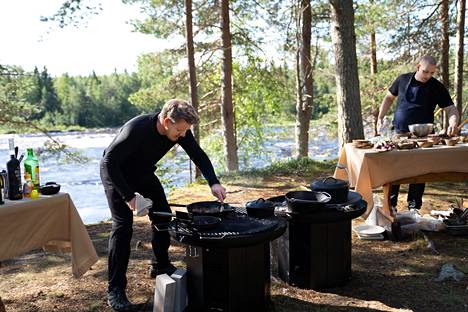 Gordon Ramsay (vasemmalla) ja Kim Mikkola kisaavat Suomi-jaksossa nuotiohiilloksen äärellä siitä, kumpi tekee paremman kattauksen ruokaa suomalaisista raaka-aineista.