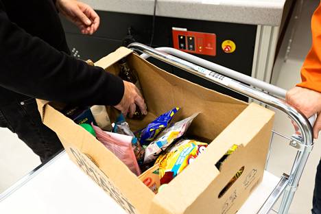 Kesko's online store logistics development manager Perttu Laakoli shows how to pack the products collected by the robot.