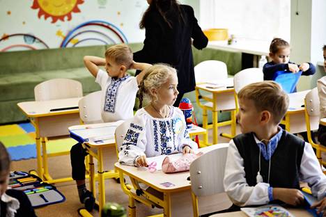 Maanantaina ensimmäisen luokan aloittanut Oleksandra (keskellä) oli monien muiden lasten tavoin puettu Ukrainan kansallisasuun.