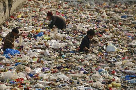 Lapset etsivät kierrätettävää muovia kanaalista Peshawarin kaupungissa Pakistanissa tammikuussa. Muovia tuotetaan maailmassa vuosittain tuoreen tutkimuksen mukaan yli 300 miljoonaa tonnia.