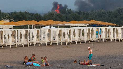 Novofedorivkan lentotukikohdan lähistöllä rantalomaa viettävien ihmisten taustalla näkyi tulenlieskoja ja savua tiistaina. 