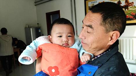 Li Zhiqiang lämmittää kotiaan sähköisellä lämpöpuhaltimella, jotta tyttärenpoika Cui Haochenilla ei olisi kylmä