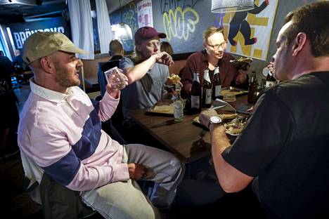 Ville Mikkola (left), Aleksi Taivalantti, Mika Salmi and Joona Huovinen enjoy dinner at Bröner. Mikkola, who lives in Harju, says that she would walk more often along Siltasaarenkatu to Hakaniemi if the street was not under renovation.