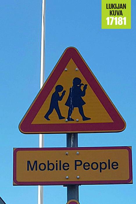 Munkkiniemessä varoitetaan kännykkää tuijottavista ihmisistä epävirallisella liikennemerkillä.