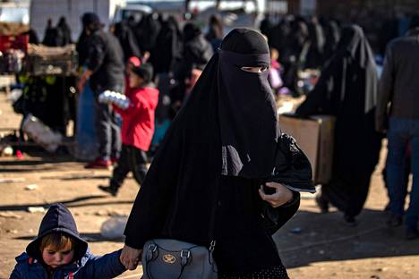 Nainen talutti lasta al-Holin leirillä 14. tammikuuta.