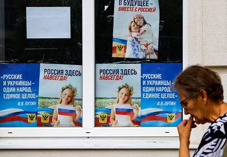 Venäjän hallitsemassa Hersonin kaupungissa kaduille on kiinnitetty Venäjä-myönteisiä julisteita, joissa lukee ”Tulevaisuus – yhdessä Venäjän kanssa”, ”Venäjä on täällä ikuisesti” ja presidentti Vladimir Putinin sitaatti ”Venäläiset ja ukrainalaiset ovat yhtä kansaa, yksi kokonaisuus”. Kremlin suunnitelmien mukaan kansanäänestykset miehitettyjen alueiden liittymisestä Venäjään on tarkoitus järjestää syyskuussa 2022. Ukraina on ilmoittanut valtaavansa kaupungin takaisin syyskuuhun mennessä. Kuva on otettu 25. heinäkuuta. 