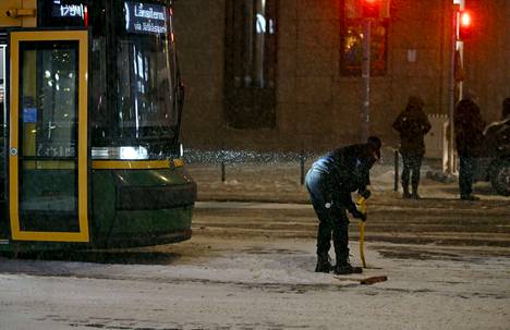 Raitiovaununkuljettaja puhdisti kiskoja lumipyryssä Helsingin keskustassa 12. joulukuuta.
