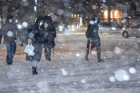 Myrsky peitti tiistaina laajoja alueita lumeen Japanissa. Ihmiset kulkivat kaupungilla Niigatassa.