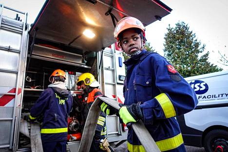 Patrick Österholm, 11, ottaa sammutusletkua ulos paloautosta vapaaehtoisen palokunnan harjoituksissa Helsingissä.