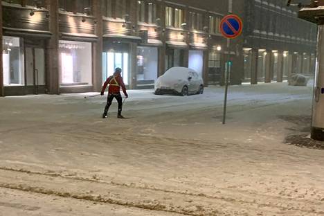 Hiihtäjä Fabianinkadun ja Aleksanterinkadun risteyksessä maanantaina yhdeksän jälkeen illalla.