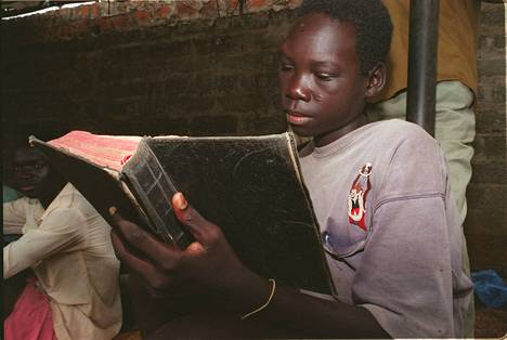 Ugandalaisesta Herran vastarinta-armeijasta karannut poika luki Raamattua avustus­järjestön tiloissa vuonna 1997.