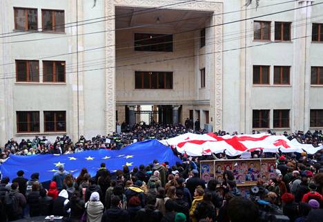 Ihmiset osoittivat maanantaina mieltään kiistanalaista lakiehdotusta vastaan parlamenttitalon ulkopuolella Tbilisissä Georgiassa. 