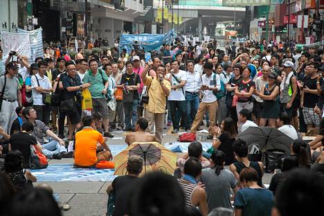 Mielenosoittajat ja ohikulkijat kuuntelivat puheita vallatulla ostoskadunpätkällä Canton Roadilla Hongkongin Tsim Sha Tsuissa viime viikon torstaina.