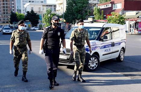 Azerbaidžanilaiset sotilaat auttoivat poliisia valvomaan tiukkojen koronarajoitusten noudattamista maan pääkaupungin Bakun kaduilla heinäkuussa.