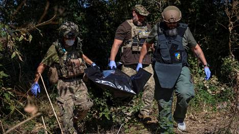Ukrainalaissotilaat kantoivat venäläisen sotilaan ruumista Donetskin alueella viime syksynä.