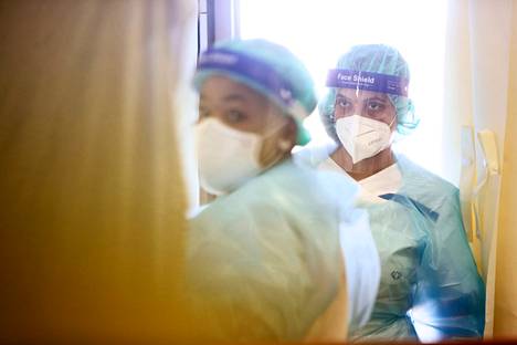 Sairaanhoitajat työssään Herttoniemen koronasairaalan eristyshuoneessa.