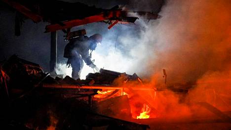 Ukrainalainen pelastustyöntekijä sammuttamassa Venäjän iskun aiheuttamaa tulipaloa Tšerkasyn alueella perjantain vastaisena yönä.