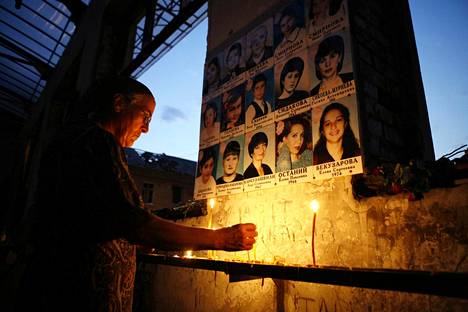 Nainen sytyttämässä kynttilää Beslanin koulukaappauksen muistoksi asetetulla muistomerkillä vuonna 2007. Putin käytti terrorismia perusteluna liittovaltion tiivistämiselle.