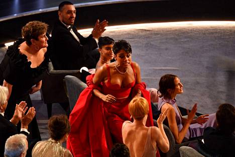 Ariana DeBose voitti Oscarin parhaasta naissivuosasta elokuvassa West Side Story. Kuvassa hän on nousemassa paikaltaan ja lähdössä lavalle vastaanottamaan palkintoa.
