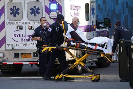 Kasvosuojalla varustettua potilasta siirrettiin ambulanssista sairaalaan Manhattanilla New Yorkissa keskiviikkona.