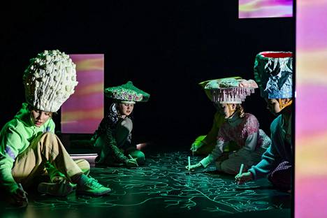 Viiden lapsen muodostama kuoro esittää kaiken yhteen sitovaa sienirihmastoa Espoon Revontulihallissa esitettävässä utopiassa.