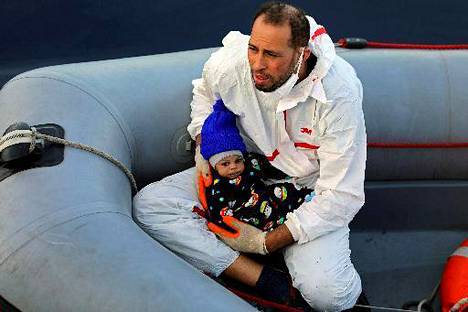 Pelastustyöntekijä piti pientä vauvaa sylissään, kun Libyan rannikkovartiosto pelasti Eurooppaan pyrkineitä siirtolaisia Välimereltä viime maanantaina 15. tammikuuta.