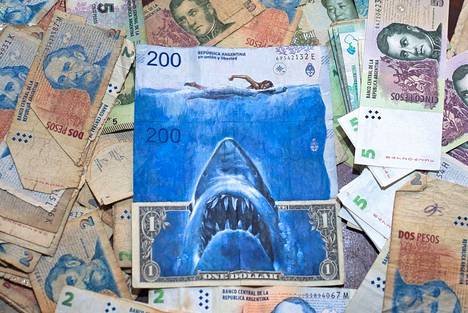Taiteilija Sergio Díaz kommentoi Argentiinan peson syöksykurssia elokuvajulisteesta tutulla tappajahailla, joka nousee Yhdysvaltain dollarin setelistä.