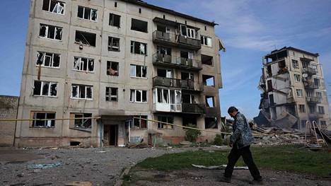 Paikallinen asukas käveli Venäjän ilmaiskun tuhoaminen kerrostalojen ohitse Otšeretynen kaupungissa Itä-Ukrainassa kuluvan kuun 15. päivänä.