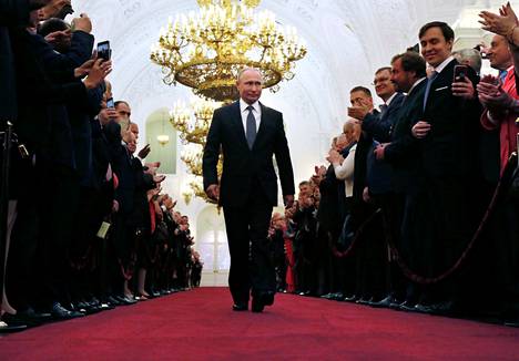 Vladimir Putin marssi Kremlin käytävällä suosionosoitusten saattelemana uuden presidenttikautensa virkaanastujaiseremoniaan toukokuussa 2018.