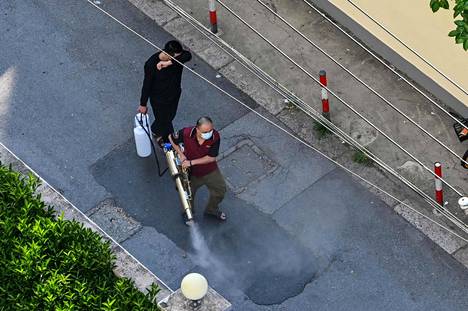 Mies puhdisti katua desinfiointiaineella Jing’anin kaupunginosassa Shanghaissa 6. toukokuuta.
