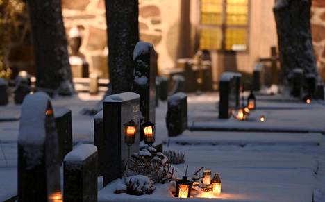Kynttilöitä kuvattuna Espoon kirkon hautausmaalla jouluaattona 2021.