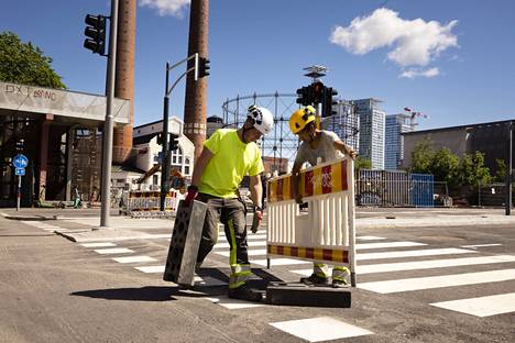 Työnjohtaja Heikki Pulkkinen ja lapiomies Naim Rajabi nostivat työmaa-aidan valmiin kadun edestä. Avauspäiväksi valikoitui perjantai, jotta ihmiset tottuvat uuteen reittiin viikonlopun aikana.
