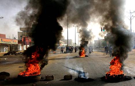 Sudanilaiset mielenosoittajat polttivat renkaita ja rakensivat tiesulkuja maanantaina Khartoumissa.
