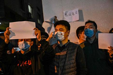 Mielenosoittajat pitelivät tyhjiä valkoisia paperiarkkeja Shanghaissa sunnuntaina. Paperit symboloivat Kiinan olematonta sananvapautta.