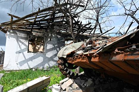 Hylätty venäläinen tankki tuhoutuneen asuinrakennuksen vieressä Harkovan lähellä sijaitsevassa kylässä.