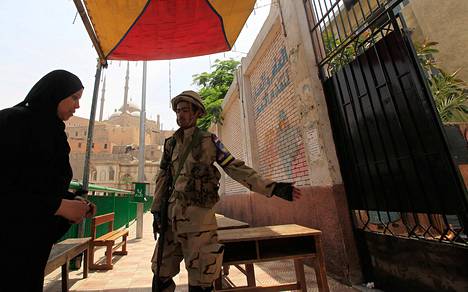 Sotilas ohjasi naisen äänestyspaikalle Kairossa keskiviikkona.